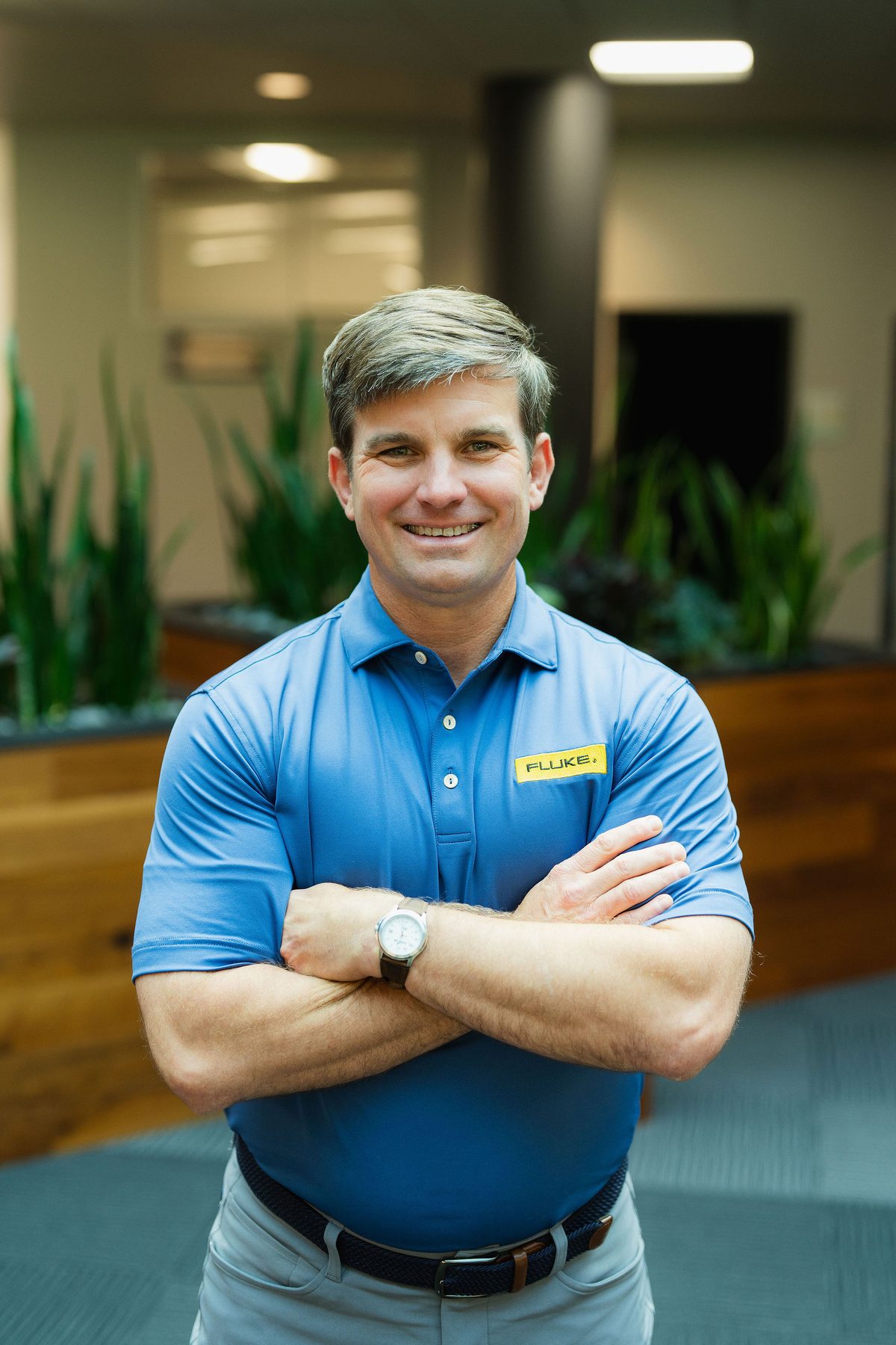 Parker Burke standing with arms crossed in the Fluke lobby in Everett