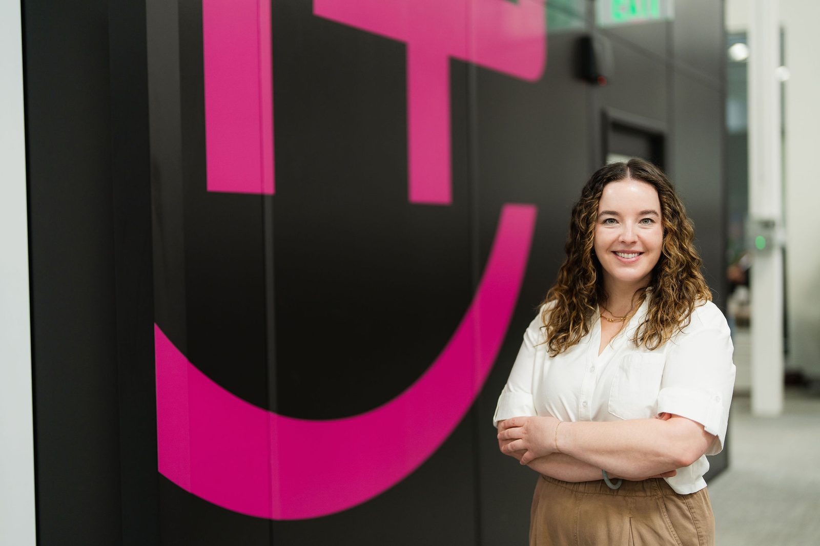 Savanna Thompson standing in front of the Helion logo wall at the Everett headquarters
